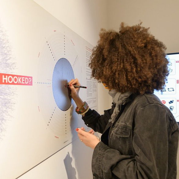 a person participating in an interactive exhibition. they are drawing on a wall