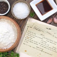 A photo of a bowl of flour, salt and peppercorns next to recipe index cards