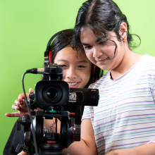 Two teen girls using a film camera