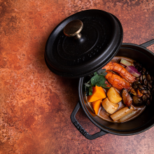 a black casserole pot containing vegetables
