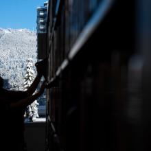 A silhouette image of someone putting a book on the shelf with a snowy mountain in the background