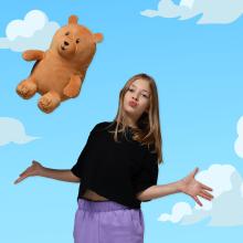 Teen girl throwing a teddy bear plush mascot toy in air, illustration of clouds and sky in background