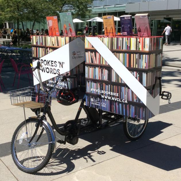 Book Bike A tricycle with a large unit on the back that is open and full of books