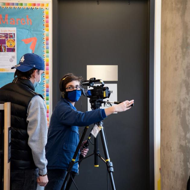 Filming for the future Photo of two people learning to use a video camera on a tripod.