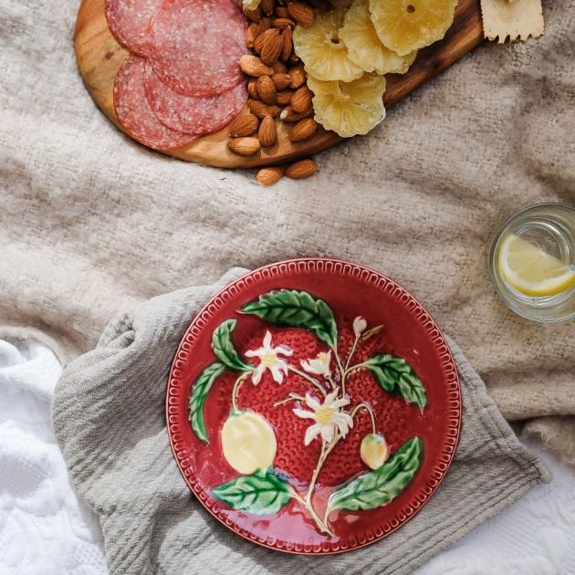 A plate and charcuterie board on a blanket. 