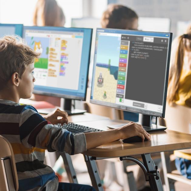 Young boy at computer learning coding programming