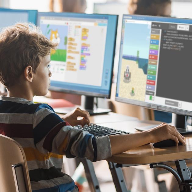 Young boy at computer learning coding programming
