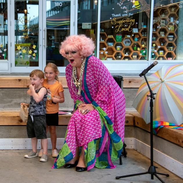 Mz. Conni Smudge A photo of local drag performer Conni Smudge with two children at a story time event.