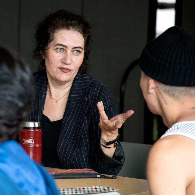 English corner A woman gesturing with her hands and speaking to a man wearing a touk