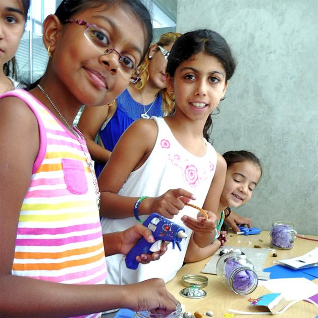 Crafternoon at City Library Children with glue gun, craft supplies, looking at camera smiling