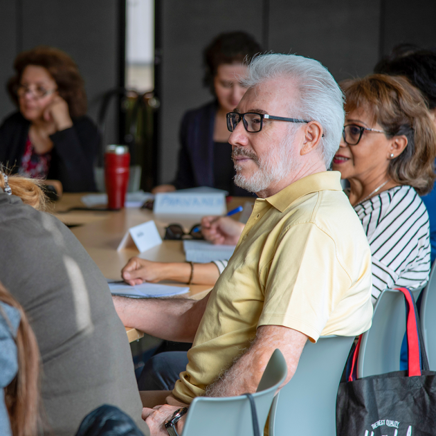 Man in yellow shirt attending a class.