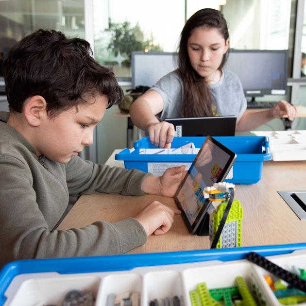 Boy and girl using tablet computers