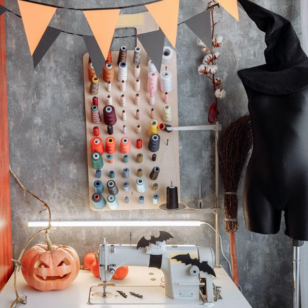 Halloween costumes A photograph of a sewing machine with spools of thread, pumpkins and a dress form