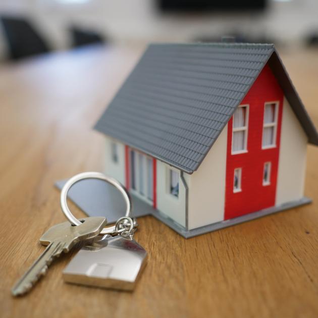 A key in front of a small model house