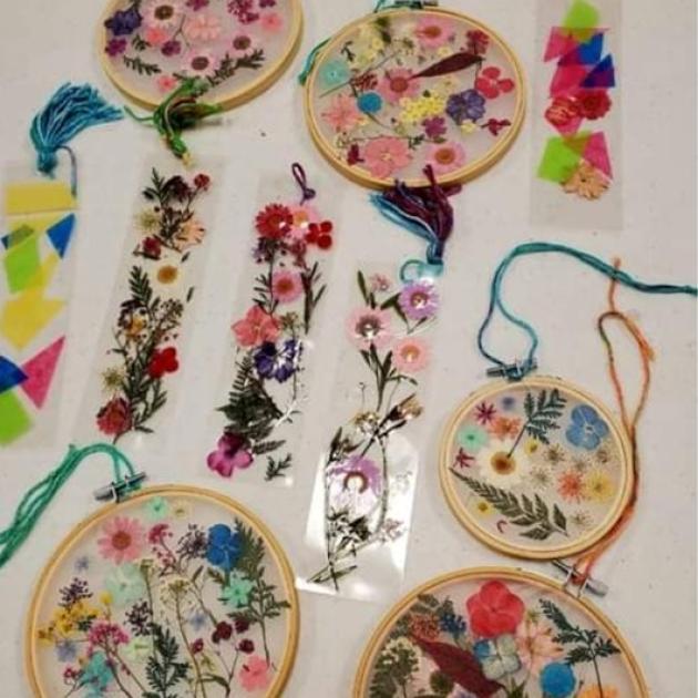 Hanging art pieces using dried flowers within embroidery loops. 