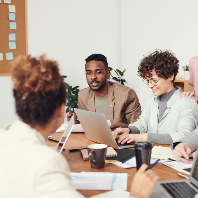 Groupe of people sitting around the desk