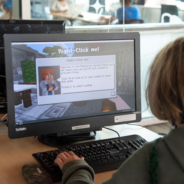 A child playing Minecraft on a computer A child playing Minecraft on a computer