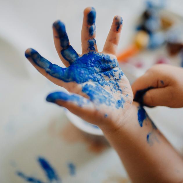 Child's hand covered in blue paint