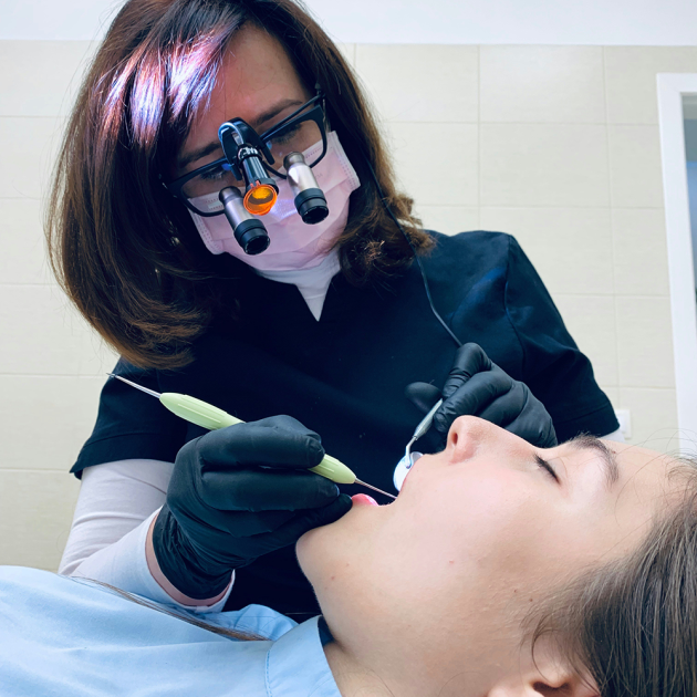 A dentist or dental hygienist is working on a patient