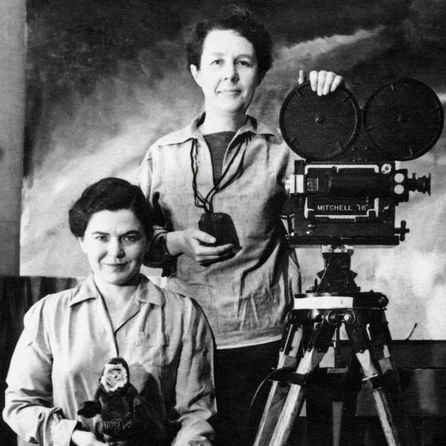 A Return to Memory Two women stand next to an old film camera