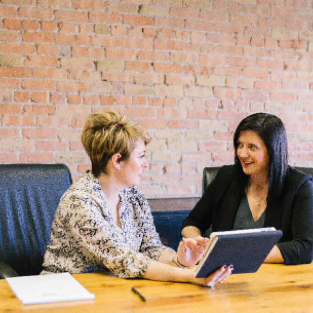 Workplace rights and responsibilities Two women sitting behind a desk and talking