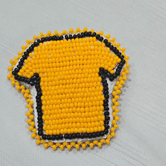Beaded pin workshop A photograph of a beaded pin in the shape of an orange T-shirt with a black outline