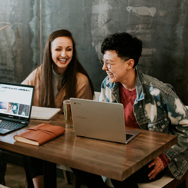 a man and a woman sitting in front of a laptop a man and a woman sitting in front of a laptop