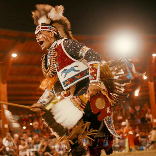 Sugarcane film screening Photograph still from a film of Indigenous dancer wearing ceremonial attire