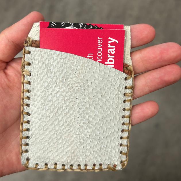 Hand holding stitched fish leather card wallet with City Library card inside