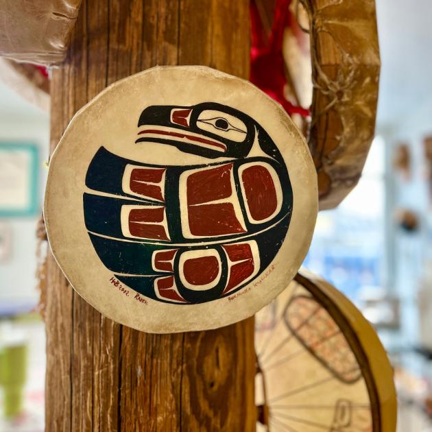 Coast Salish art on handmade drum hanging on a wooden pole