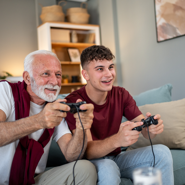 a grandfather and grandson on a couch playing video games