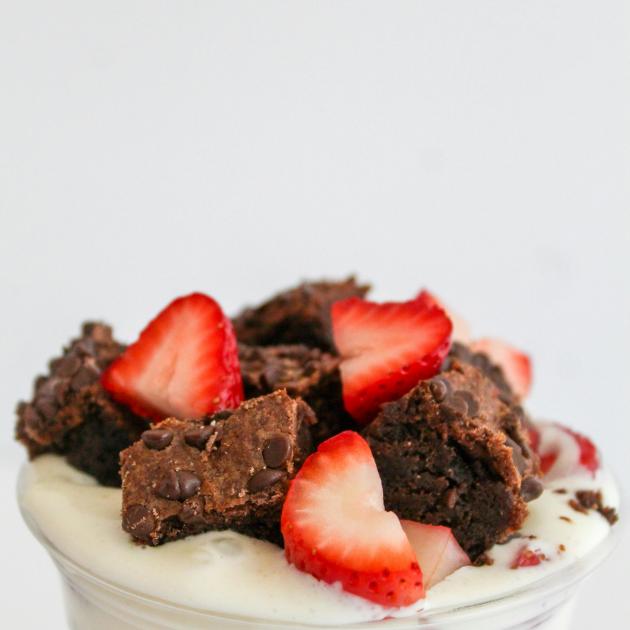 A yogurt cup with fruit and brownies