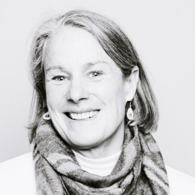 A black and white photo of Stephanie Jansen, a career counsellor with parted, chin-length hair, wearing a stripped scarf, smiles at the camera.