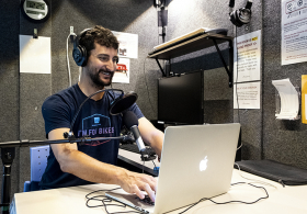 Man smiling while using recording equipment at the library