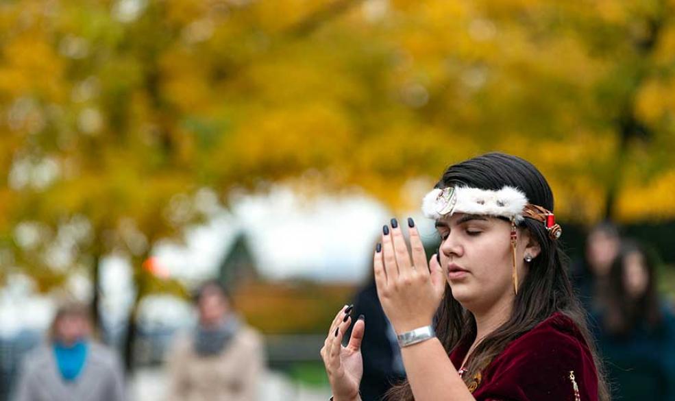 Indigenous woman doing dance for canoe ceremony