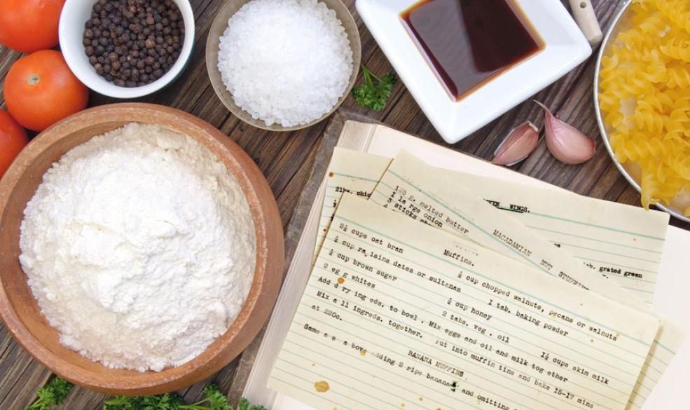 A photo of a bowl of flour, salt and peppercorns next to recipe index cards