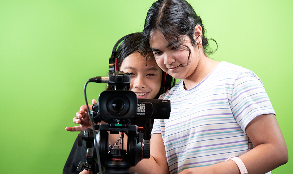 Two teen girls using a film camera