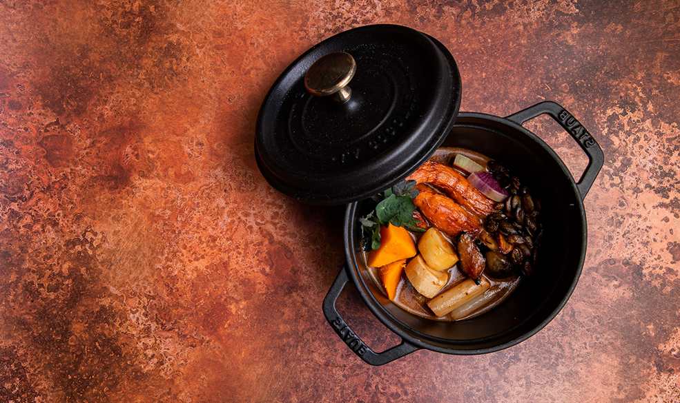 a black casserole pot containing vegetables