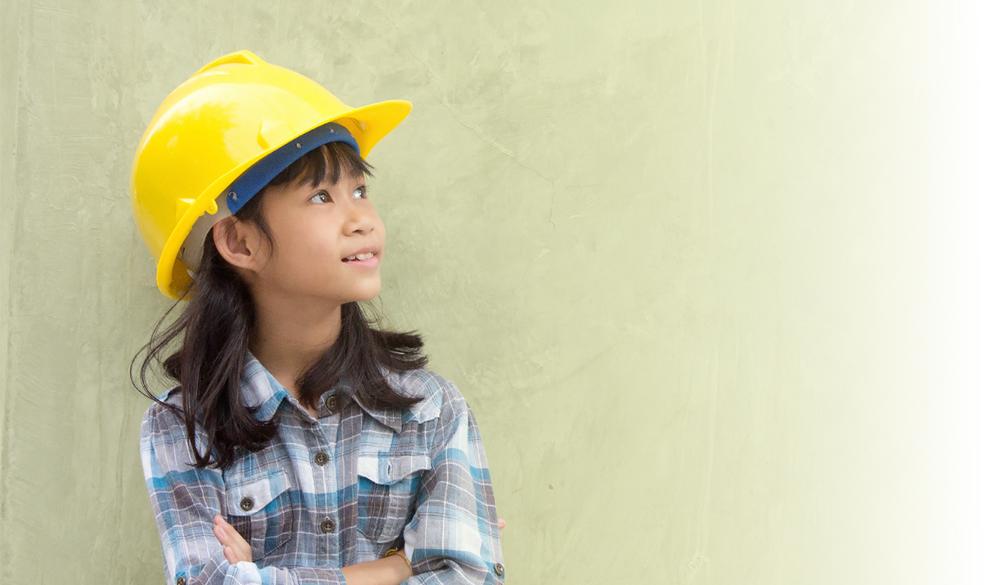 Young girl in construction hard hat looking to the side