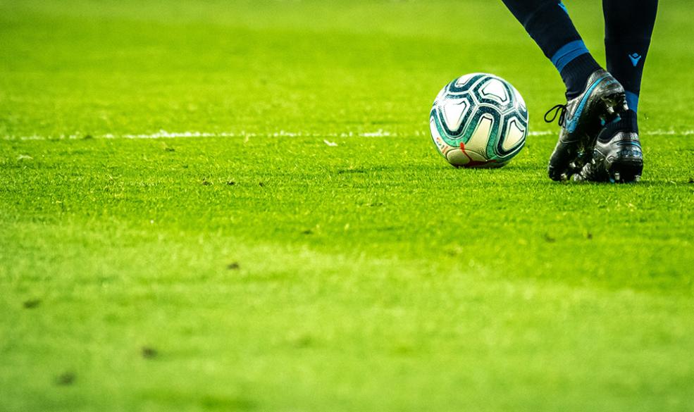 closeup of the boots of a soccer player dribbling a ball
