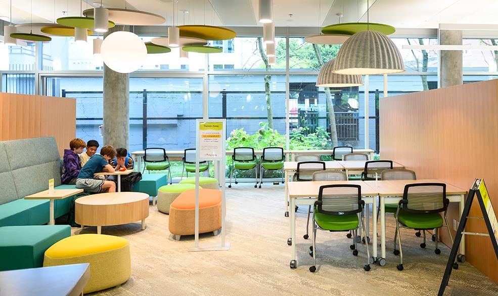 a group of tweens huddled around a table in the library's tween zone