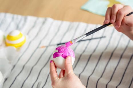 Picture of person painting an egg with pink paint
