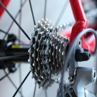 A closeup of the rear sprocket of a red bicycle