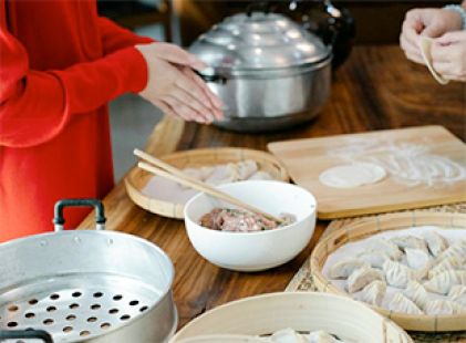 Two people cooking dumplings