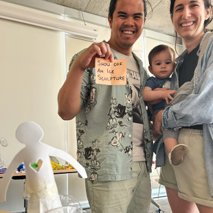 Two parents with their baby at a TASK party