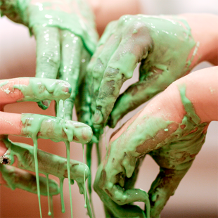 Hands covered in green oobleck slime