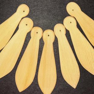 Wooden paddles arranged in an arc on a dark background